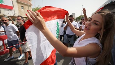 مغتربون لبنانيون يرقصون وهم يقفون في طابور للإدلاء بأصواتهم في الانتخابات التشريعية المقرّر إجراؤها في 15 أيّار في القنصلية اللبنانية في إمارة دبي (أ ف ب).