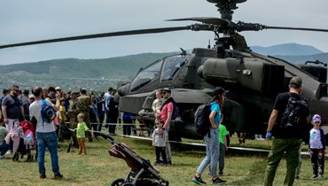 زوار يقفون قرب طائرة هليكوبتر أميركية معروضة خلال افتتاح معرض طائرات الناتو في ستينكوفيتش بجوار سكوبي (8 ايار 2022، أ ف ب). 