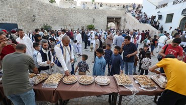 ليبيون يوزعون الحلويات عند بوابة باب الجديد بالمدينة القديمة بالعاصمة طرابلس، في مناسبة عيد الفطر (4 ايار 2022، أ ف ب). 