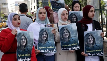 نساء تحملن صور للشهيدة شيرين أبو عاقلة (أ ف ب).