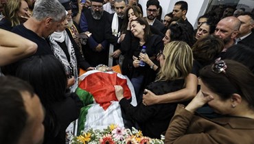 صحافيات وصحافيون وأصدقاء يلتفون حول جثمان الصحافية شيرين أبو عاقلة في مكتب قناة "الجزيرة" برام الله أمس (أ ف ب).