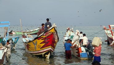 صيادون يمنيون يعودون مع صيدهم الى شاطئ في مديرية الخوخة بمحافظة الحديدة الغربية (7 ايار 2022ـ أ ف ب). 