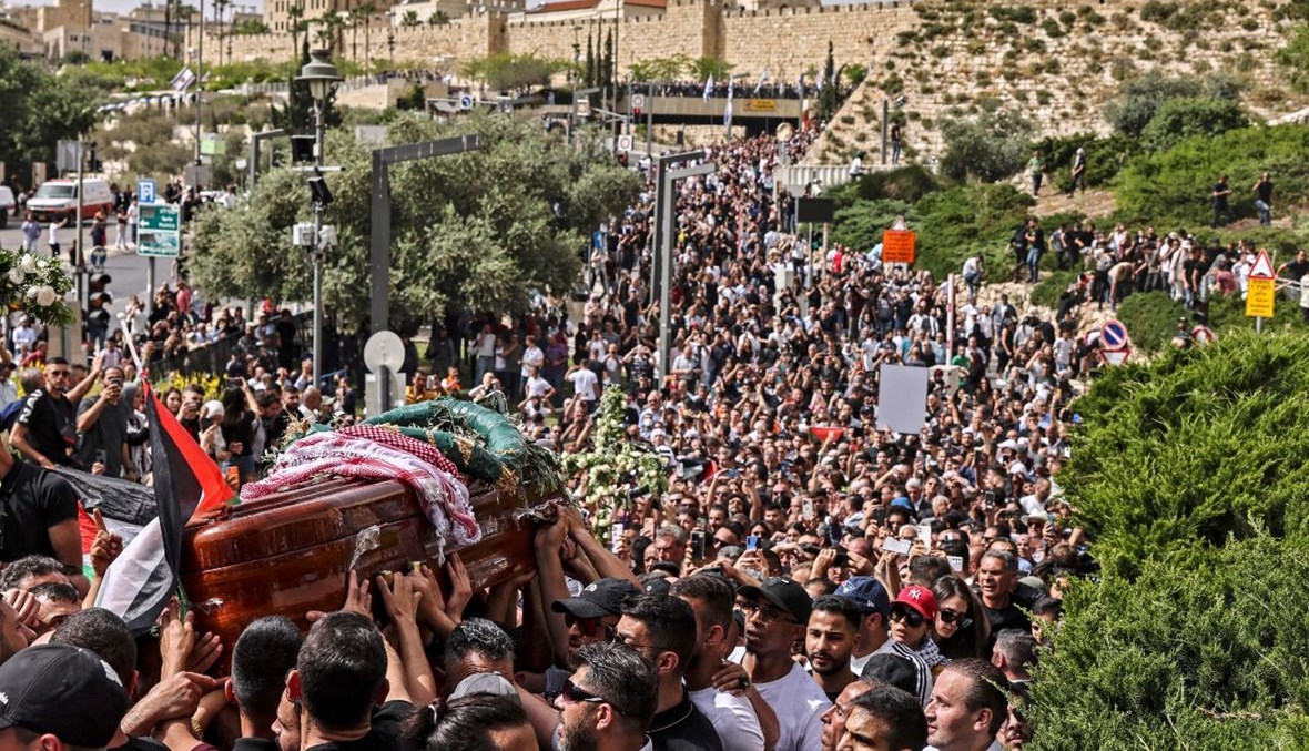 مشيعون فلسطينيون يحملون نعش شيرين أبو عاقلة من الكنيسة باتجاه المقبرة في القدس (13 ايار 2022، أ ف ب). 