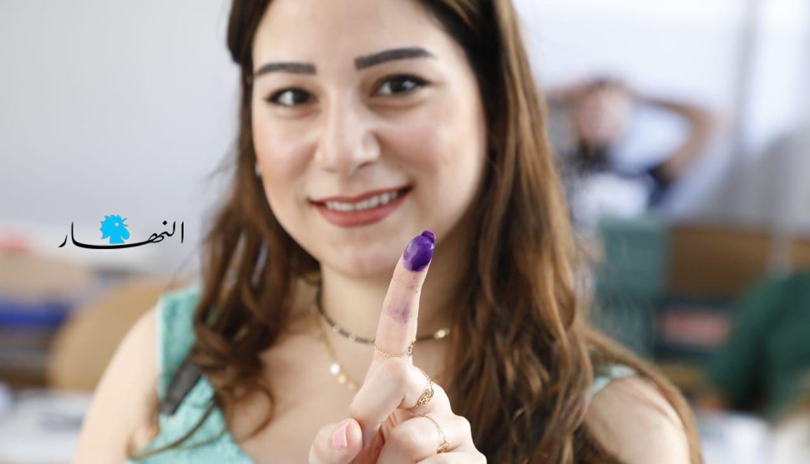 مواطنة ترفع إصبعها بعد إتمام عملية الاقتراع.
