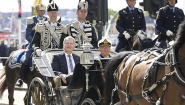 الرئيس الفنلندي سولي نينيستو )إلى اليسار( جلس بجوار ملك السويد كارل غوستاف بينما يركبان عربة خيول في وسط ستوكهولم (17 ايار 2022، أ ب). 