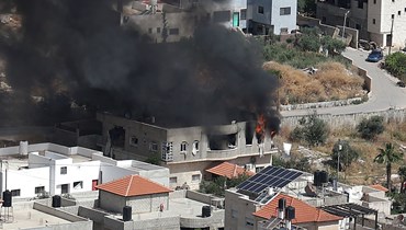 دخان يتصاعد من مبنى في مدينة جنين بالضفة الغربية عقب غارة عسكرية إسرائيلية (13 أيار 2022 - أ ف ب).