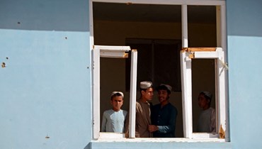 أولاد ينظرون من نافذة في مدرسة متضررة في قندهار (12 ايار 2022، أ ف ب). 