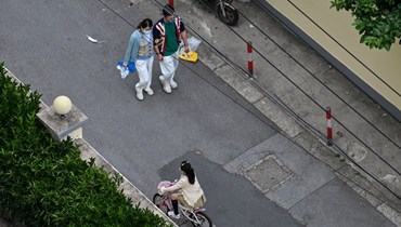 سكان يمشون في شارع في حي جينغان في شنغهاي خلال الاغلاق (19 ايار 2022، أ ف ب).