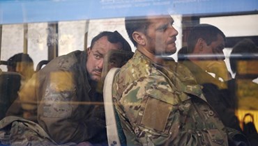 جنود أوكرانيون يجلسون في حافلة قرب الحبس الاحتياطي في أوليونيفكا بمنطقة خاضعة لحكومة جمهورية دونيتسك الشعبية شرق أوكرانيا، بعد إجلائهم من مصنع آزوفستال في ماريوبول (17 ايار 2022، أ ب). 