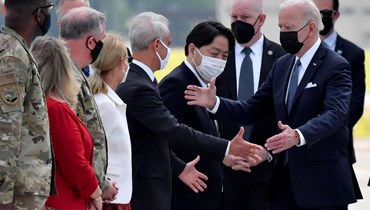 وزير الخارجية الياباني يوشيماسا هاياشي (في الوسط) والسفير الأميركي لدى اليابان رام إيمانويل (في الوسط إلى اليسار) يستقبلان بايدن لدى وصوله إلى قاعدة يوكوتا الجوية في فوسا بمحافظة طوكيو (22 ايار 2022، أ ف ب).