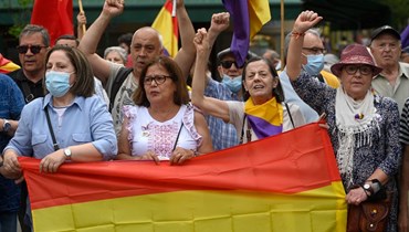متظاهرون يحملون علمًا جمهوريًا في مدريد خلال احتجاج مناهض للنظام الملكي (22 ايار 2022، أ ف ب). 