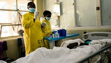 عاملان في الرعاية الصحية بأحد مستشفيات زيمبابواي (أ ف ب).