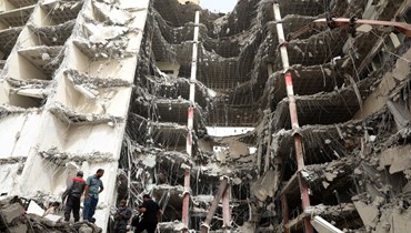 إيرانيون تجمّعوا في موقع انهيار المبنى في آبادان (24 ايار 2022/ أ ف ب). 