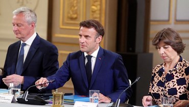 ماكرون (في وسط)، إلى جانبه وزير الاقتصاد برونو لو مير (يسار) ووزيرة الخارجية كاثرين كولونا (يمين)، خلال ترؤسه أول اجتماع لمجلس الوزراء منذ إعادة انتخابه وتعديل الحكومة (23 ايار 2022، أ ف ب). 