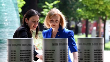 تراس (الى اليمين) وعمدة سراييفو بنيامينا كاريتش عند النصب التذكاري لأطفال سراييفو الذين قُتلوا خلال حصار العاصمة في الفترة 1992-1995 (26 ايار 2022، أ ف ب). 