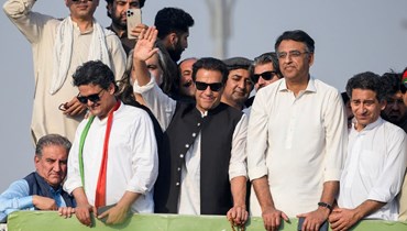 خان (في الوسط) يلوّح لمؤيديه خلال مسيرة في إسلام أباد (26 ايار 2022، أ ف ب).
