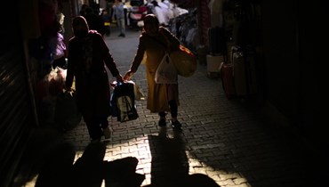 صورة تعبيرية- امرأتان تحملان أكياسا من الحاجيات في شارع تجاري في اسطنبول (14 نيسان 2022، أ ب). 