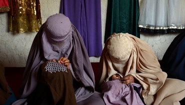 نساء يخطن الملابس خلال مشاركتهن في ورشة عمل في قندهار (21 ايار 2022، أ ف ب). 