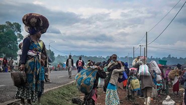 سكان يغادرون منطقة كيبومبا بأمتعتهم وماشيتهم بعد اشتباكات بين القوات المسلحة للكونغو الديموقراطية وحركة 23 آذار قرب غوما (24 ايار 2022، أ ف ب). 