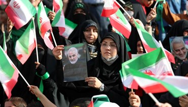 إيرانيون يلوحون بالعلم الوطني خلال تجمعهم في ملعب آزادي بطهران لحضور عرض لأغنية "سلام فارمنده" (26 ايار 2022، أ ف ب). 