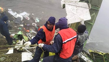 أعضاء من فريق الإنقاذ في موقع تحطّم الطائرة النيبالية (30 أيار 2022 - أ ف ب).
