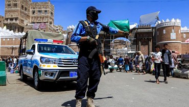 عنصر من شرطة المرور الموالية للحوثيين وقف على طريق خارج المدينة القديمة في العاصمة صنعاء (24 آذار 2022، أ ف ب). 