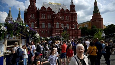 أشخاص يمشون في ساحة مانيزهنايا ميدان وسط موسكو (2 حزيران 2022، أ ف ب). 