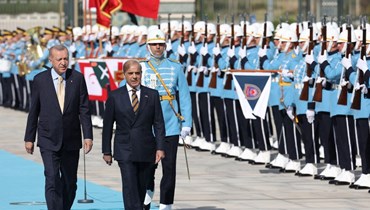 إردوغان (إلى اليسار) يستعرض مع رئيس وزراء باكستان شهباز شريف حرس الشرف في المجمع الرئاسي في أنقرة (1 حزيران 2022، أ ف ب). 