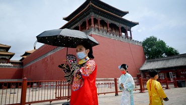 أشخاص يرتدون الزي الانتقالي الصيني المعروف باسم هانفو، خلال زيارتهم المدينة المحرمة بجينيغ (7 حزيران 2022، أ ف ب). 