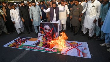 متظاهرون يحرقون صورة نوبور شارما في كراتشي (7 حزيران 2022، أ ف ب). 