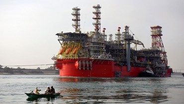  زورق قطر يسحب سفينة لتخزين وتفريغ إنتاج الطاقة العائمة (FPSO) على طول قناة السويس المصرية (أ ف ب). 