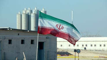 صورة أرشيفية- العلم الإيراني مرفوعاً في محطة بوشهر للطاقة النووية الإيرانية، خلال احتفال رسمي في مناسبة بدء الأعمال في مفاعل ثانٍ في المنشأة (10 ت2 2019- أ ف ب). 