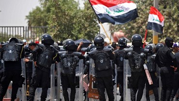 عناصر من قوات الأمن العراقية انتشروا لتفريق متظاهرين خلال اجتجاج على سياسة التوظيف الحكومية قرب مبنى البرلمان في المنطقة الخضراء ببغداد (7 حزيران 2022، أ ف ب).