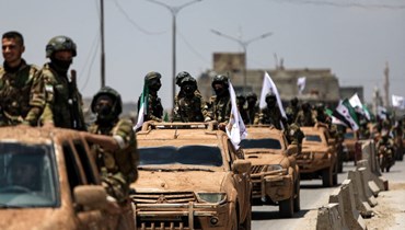 مقاتلون من المعارضة السورية المدعومة من تركيا في بلدة أعزاز الحدودية خلال توجههم نحو منطقة مقابلة لبلدة تل رفعت التي يسيطر عليها الأكراد (9 حزيران 2022، أ ف ب). 