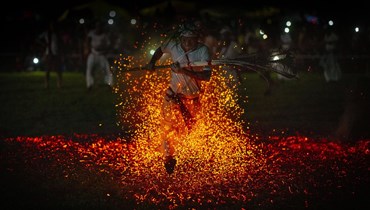 كاهن هندوسي من قبيلة رابها الهندية يجري حافي القدمين على فحم مشتعل كجزء من طقوس في مهرجان بايخو في قرية غاميريمورا غرب جواهاتي بالهند (4 حزيران 2022، أ ب). 