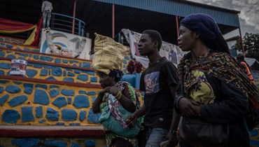 أشخاص يمشون قرب ساحة الاستقلال في بوكافو بجمهورية الكونغو الديموقراطية (11 حزيران 2022، أ ف ب). 
