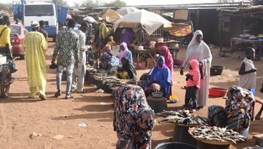باعة يبيعون الاسماك في سوق بقرية فاريه جنوب غرب النيجر قرب حدود بوركينا فاسو (9 حزيران 2022، أ ف ب). 