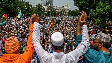  نشطاء مسلمون مع عضو (الى اليسار) من منظمة راماكريشنا الدينية والروحية الهندوسية، يشاركون في مسيرة الوحدة لتعزيز الانسجام المجتمعي في كولكاتا (14 حزيران 2022، أ ف ب). 