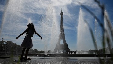 فتاة صغيرة وقفت عند نوافير تروكاديرو في باريس في ظل درجات حرارة عالية (16 حزيران 2022، أ ف ب).