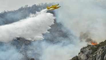 طائرة إطفاء تلقي الماء على حريق بالقرب من ارتيزا دي سيغري في كاتالونيا  بإسبانيا (16 حزيران 2022، ا ف ب).