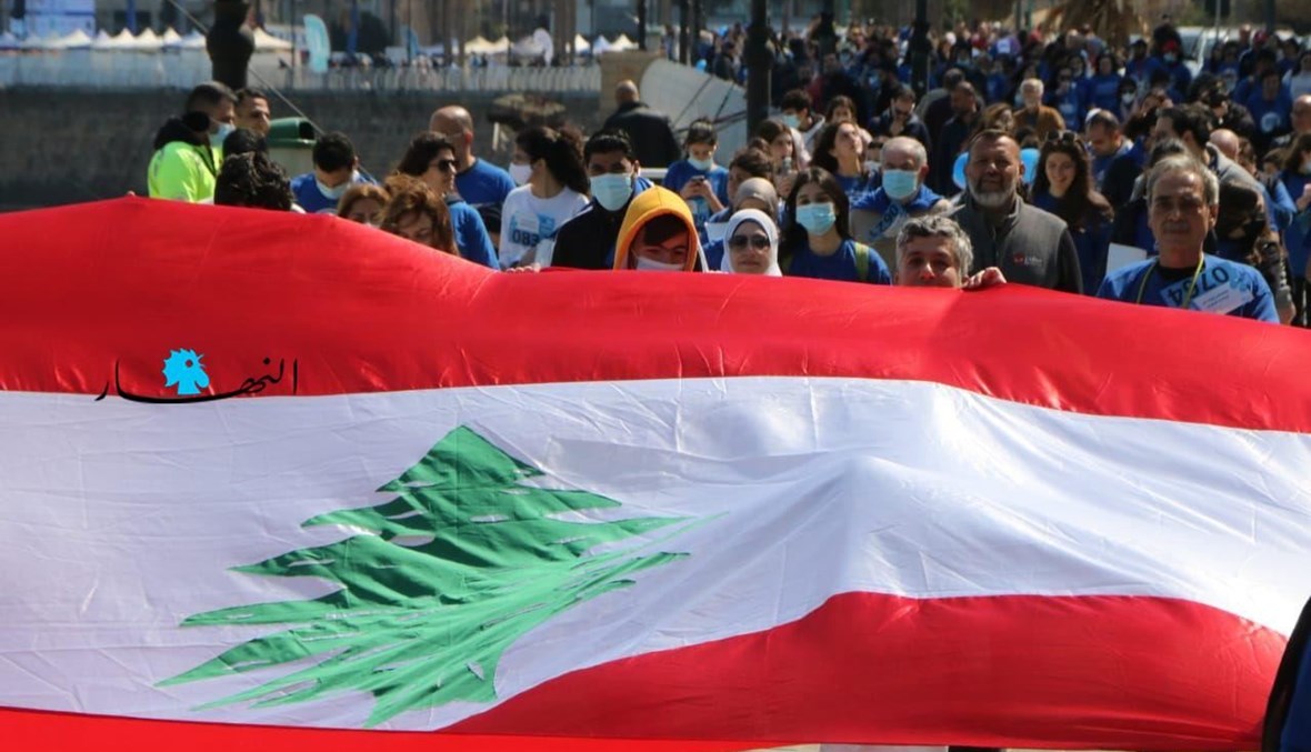 رفع العلم اللبناني في مسيرة في بيروت (تعبيرية- حسن عسل).