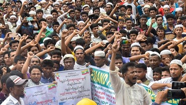 لاجئون من الروهينغيا يتظاهرون في مخيم كوتوبالونغ للروهينغيا في كوكس بازار للمطالبة بالعودة إلى بورما (19 حزيران 2022، أ ف ب). 