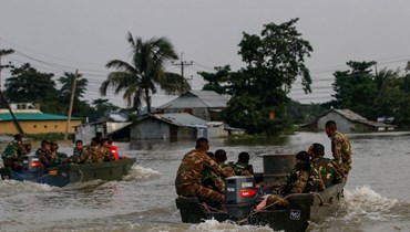 جنود في الجيش البنغلاديشي يقومون بدوريات في مناطق غمرتها الفيضانات لإنقاذ المتضررين بعد هطول أمطار موسمية غزيرة في سونامجونج (19 حزيران 2022، أ ف ب). 