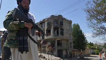 مقاتل من طالبان يقف أمام معبد للسيخ في كابول بعد هجوم شنه عليه مسلحون (18 حزيران 2022، أ ف ب). 