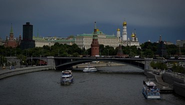 قوارب تبحر على نهر موسكفا بينما تلوح في الأفق سحب داكنة فوق الكرملين وسط موسكو (17 حزيران 2022، أ ف ب).