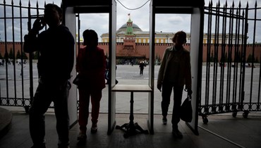 أشخاص يمرون عبر بوابات الأمن قبل دخول متجر GUM قرب الساحة الحمراء في موسكو (20 حزيران 2022، أ ف ب). 