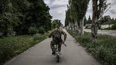 جندي أوكراني يركب دراجة صغيرة في مدينة ليسيتشانسك في منطقة دونباس، شرق أوكرانيا (18 حزيران 2022 - أ ف ب).