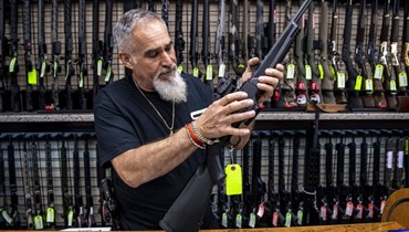 البائع جون ليكاتا يعرض بندقية في هيمبستيد بنيويورك (23 حزيران 2022، أ ب). 