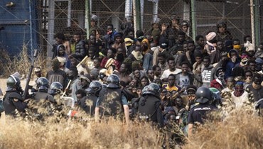 عناصر من شرطة مكافحة الشغب يطوقون منطقة بعد اقتحام مهاجرين السياج الفاصل بين جيب مليلية الإسباني والمغرب في مليلية بإسبانيا (24 حزيران 2022، أب ). 