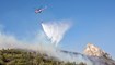 هليكوبتر تطفئ حريق غابة في جبال كيرينيا (24 حزيران 2022، أ ف ب). 